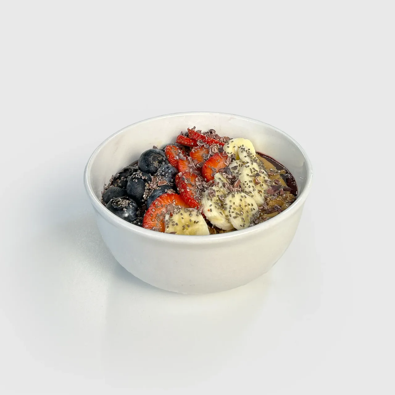 An açaí bowl topped with banana, strawberries, blueberries, chia and granola